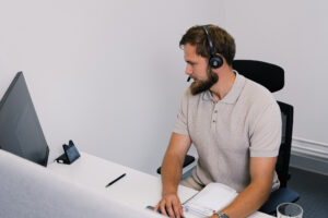 Salesperson with a headset making a call, showing how to start a cold call